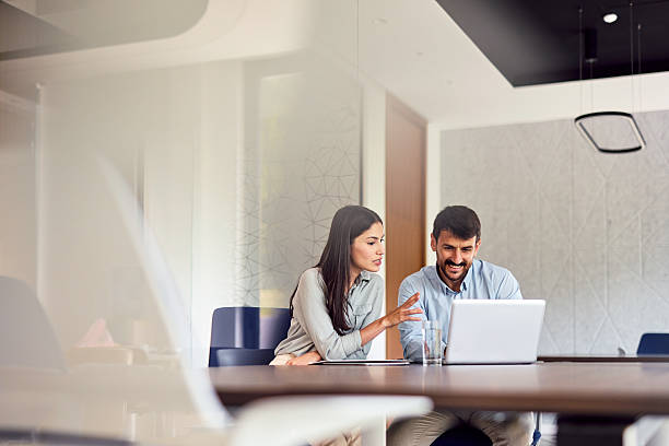 Dos jóvenes empresarios trabajando juntos en una oficina moderna